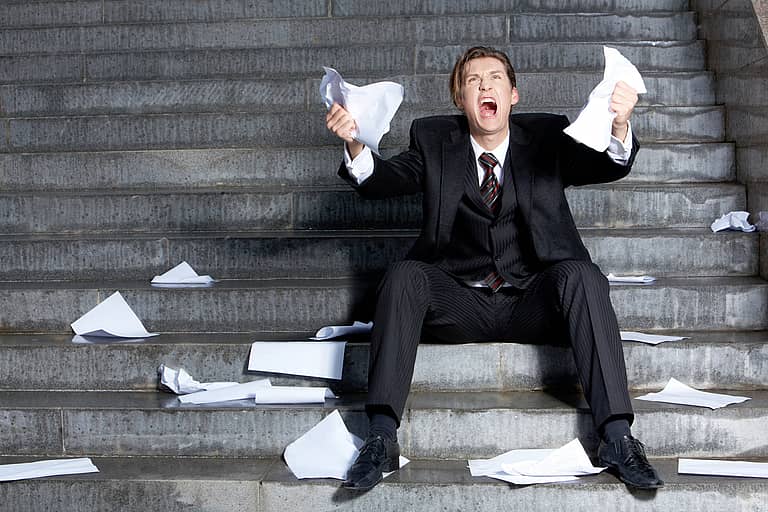 Image of grieving businessman crying with papers in hands