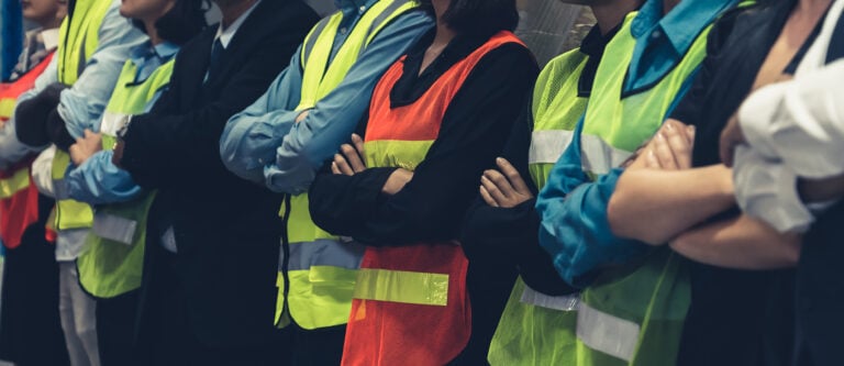 Large group of factory worker standing together in warehouse or storehouse . Logistics , supply chain and warehouse business concept .